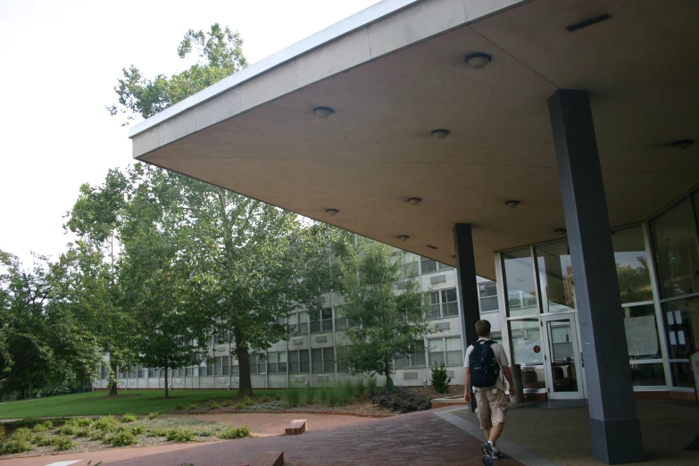 the man is going out into the woods in front of the building