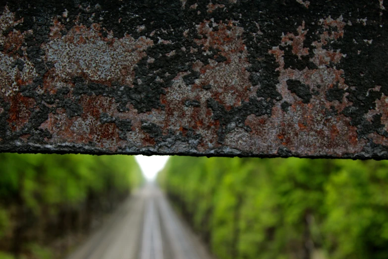 an old rusty looking rail with a red and black paint