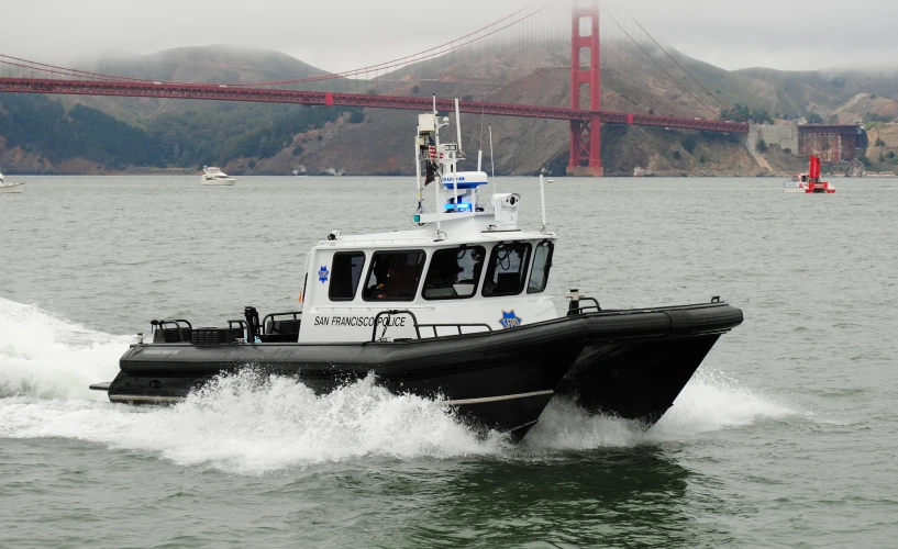 a large boat moving across water in front of a bridge