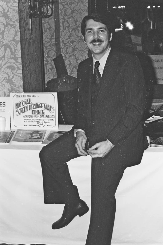 a man sitting on top of a table in a room