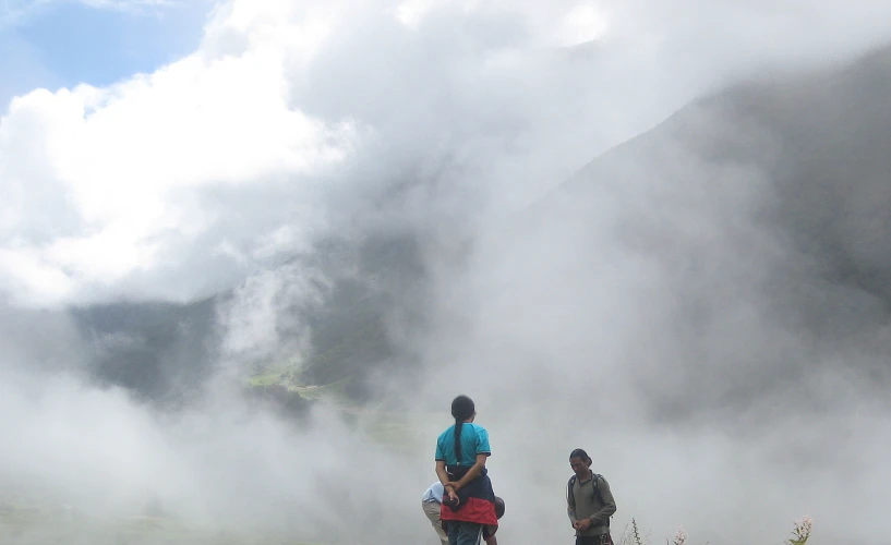 two people standing on a grassy hill above a steam emitting hill