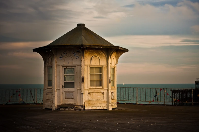 an old wooden tower standing on the side of a pier