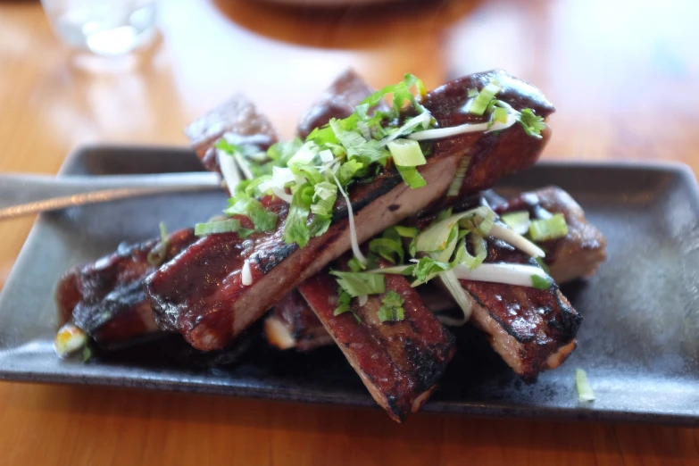 a square black plate holds several food items