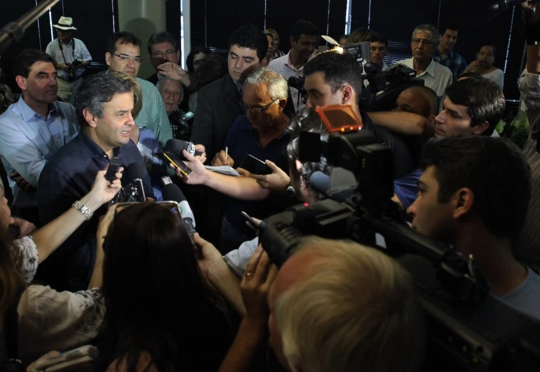 there is a man surrounded by microphones at an event