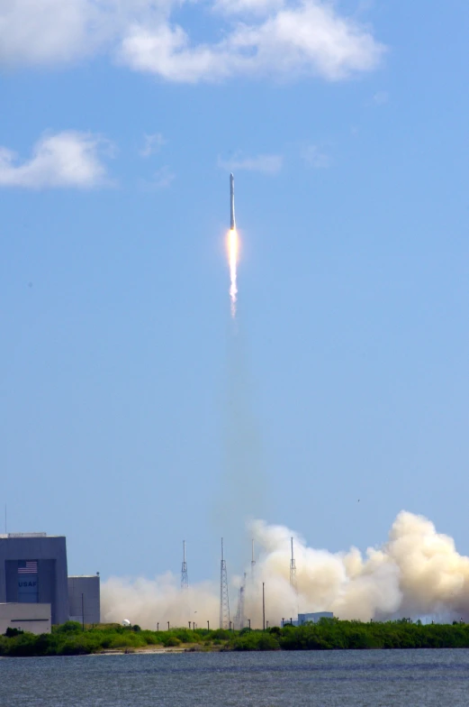 a rocket launches in the sky above a river