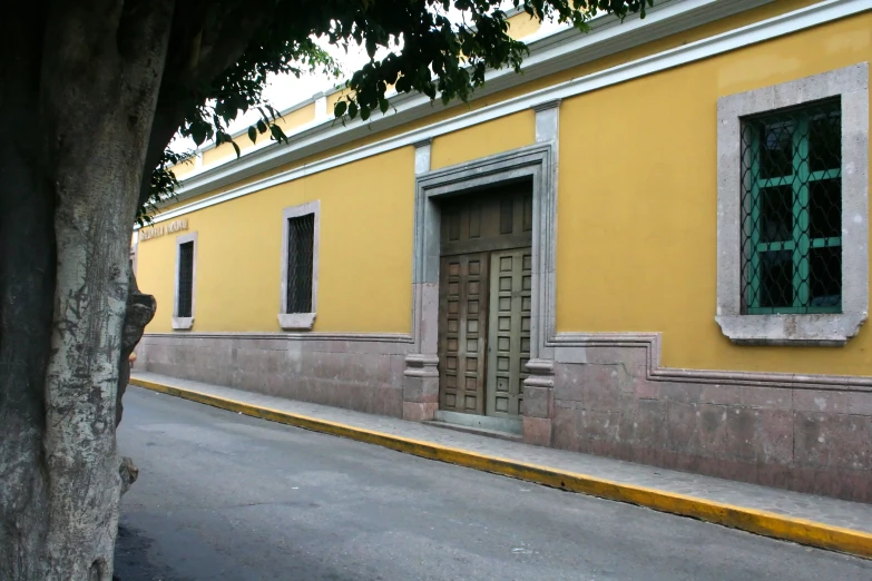 an old street with a building and yellow wall