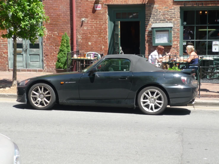 a gray convertible car parked on a side street