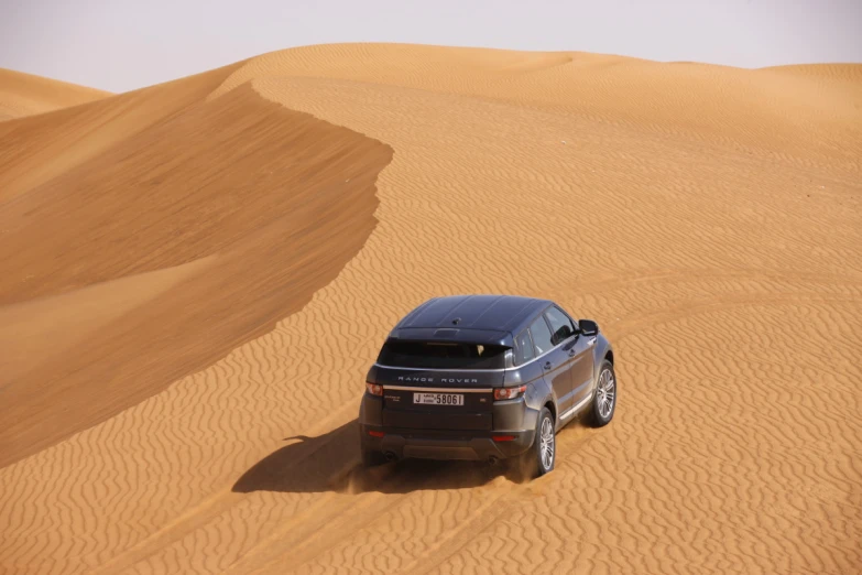 a suv parked on top of sand dunes