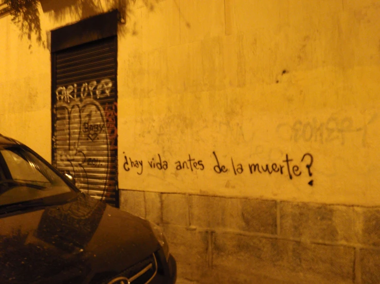 a graffiti on the side of a building near a car