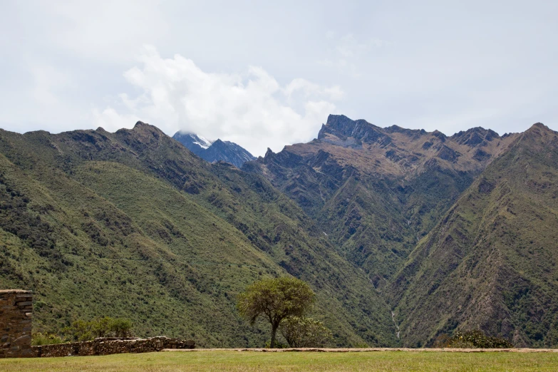 some hills with trees and mountains are in the distance