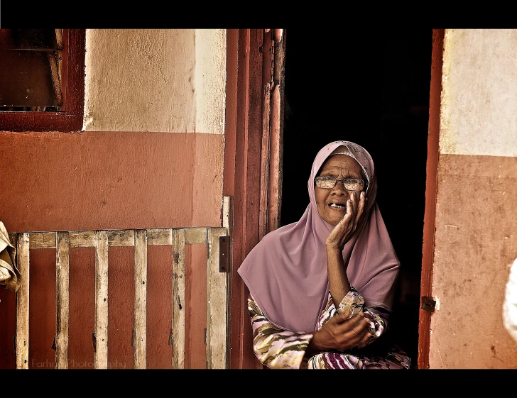 a woman talking on a cell phone in front of a doorway