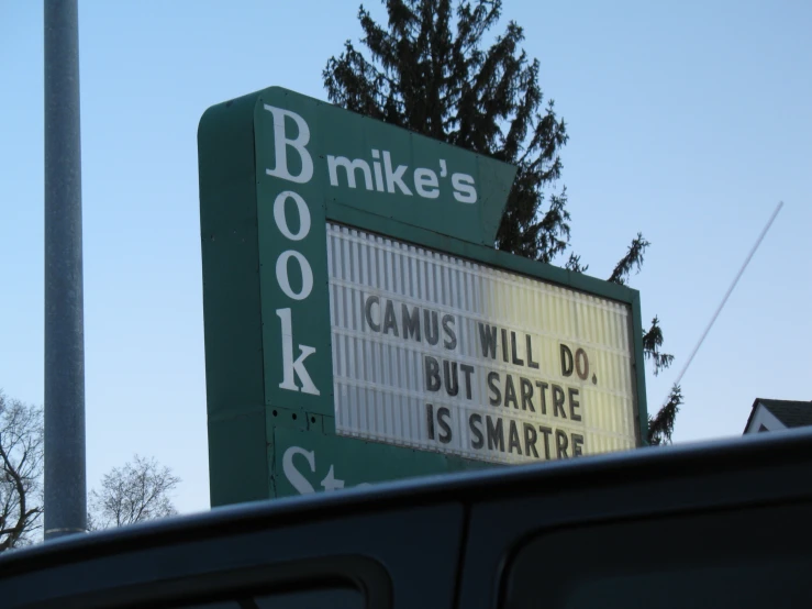 a parking sign next to a road with trees