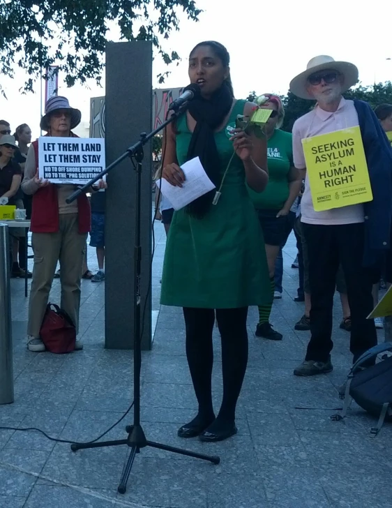 a woman standing on the street with other people holding signs