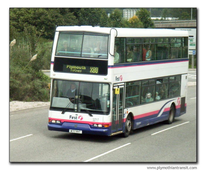 a double deck bus driving down a street