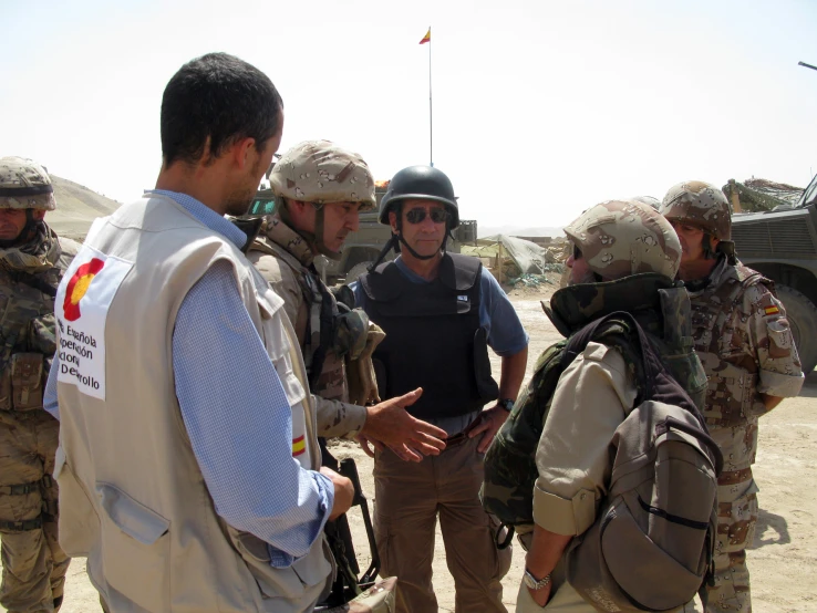 a man talking to soldiers and other military personnel