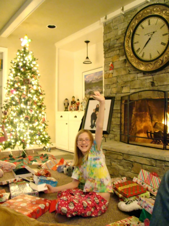 this is a  sitting under a christmas tree holding an presents