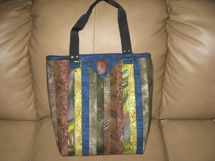 a multi - colored striped handbag with a metal handle