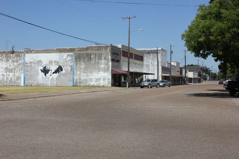 a white building with red lettering is seen on the wall of the street