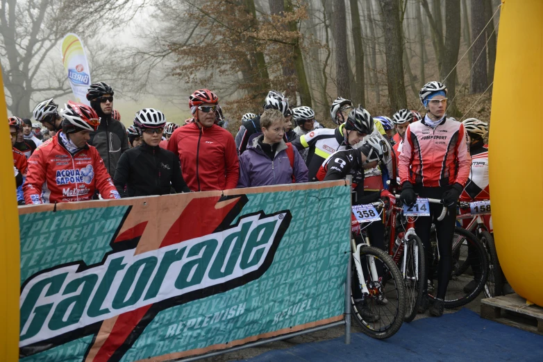 a group of people are standing behind a sign with bikes