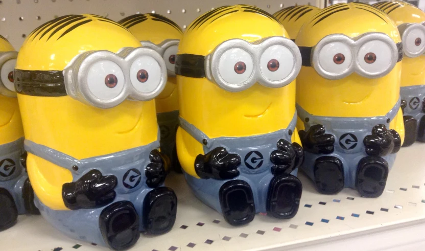 a close up of four yellow minions on a shelf