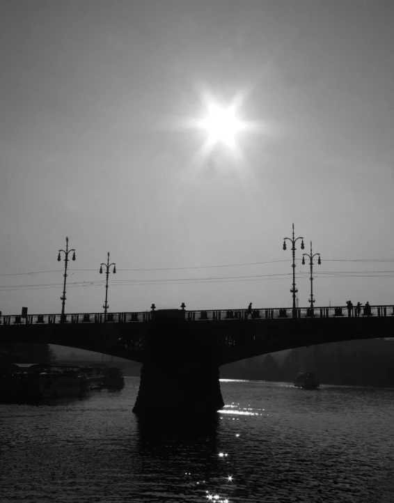 the sun is shining bright over a bridge