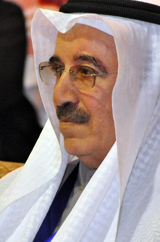 a man wearing a veil and glasses at a ceremony
