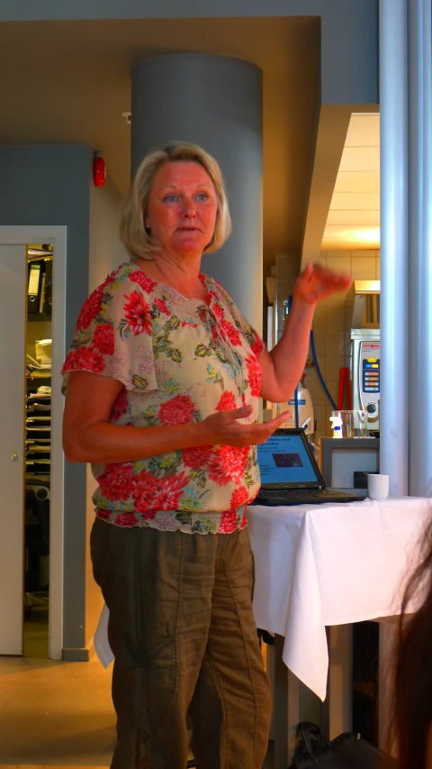 a woman standing in front of a laptop computer