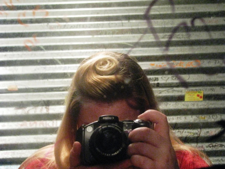 a woman takes a picture of herself holding a camera