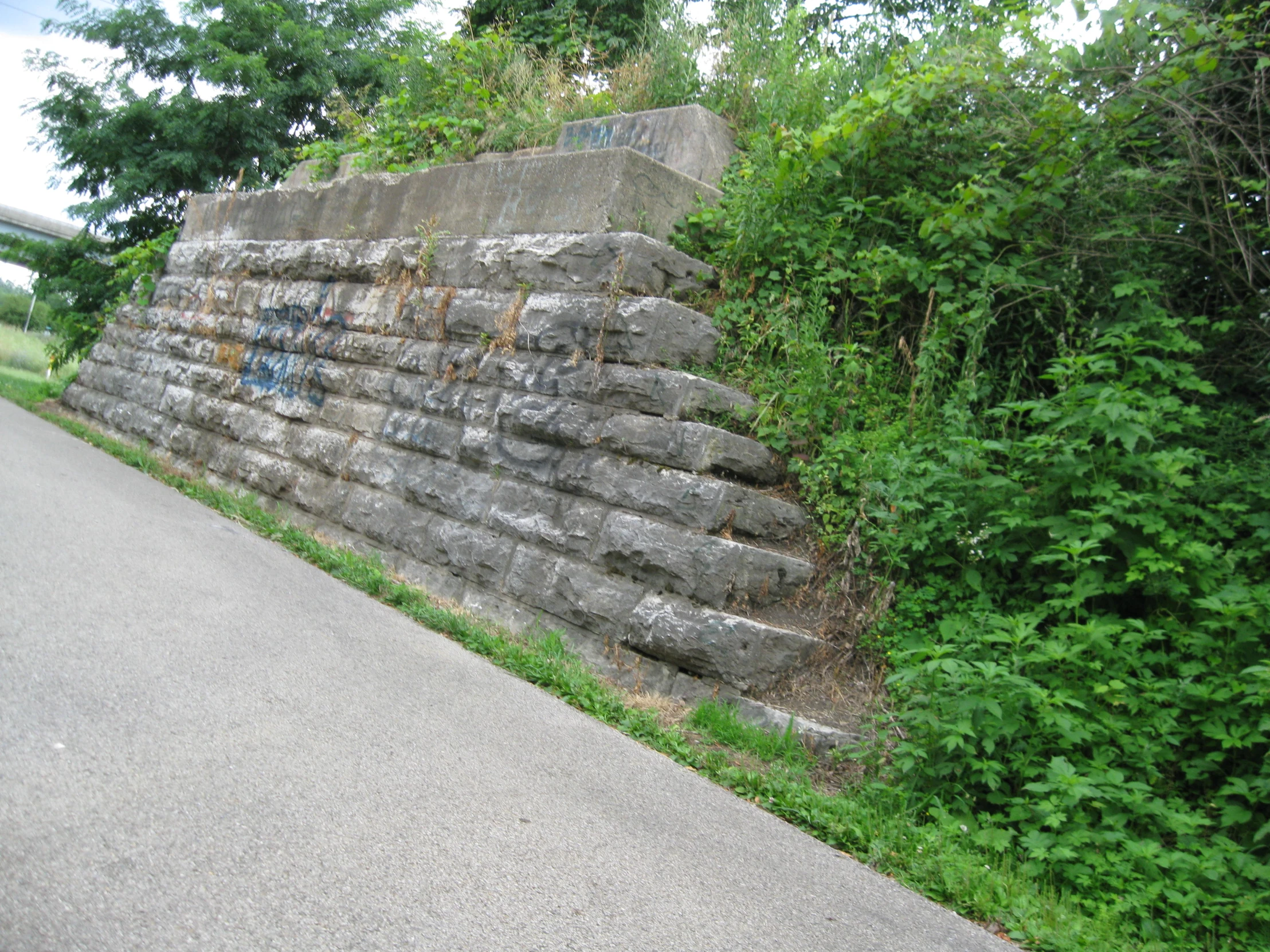 there is a brick wall by the side of the road