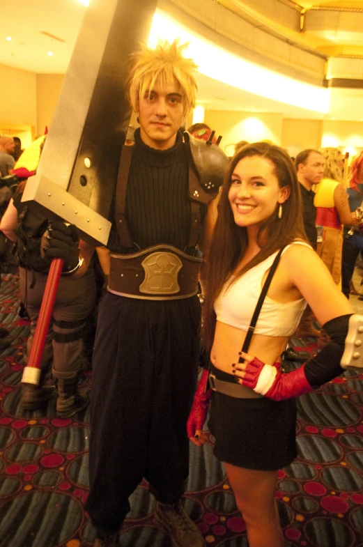 two people are posing with a giant sword