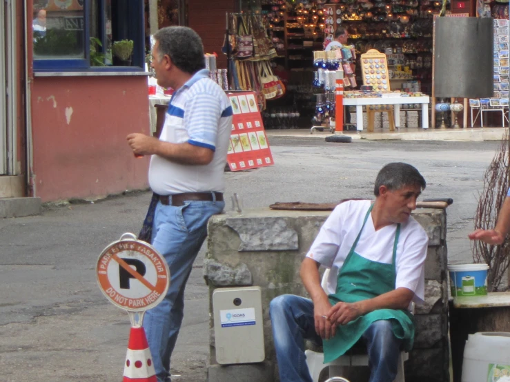 a man is waiting for soing to happen in the middle of an open market