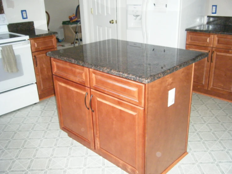 an empty kitchen with marble counter tops and white appliances