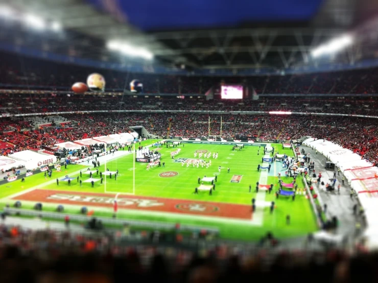 a sports field with many players in the stands