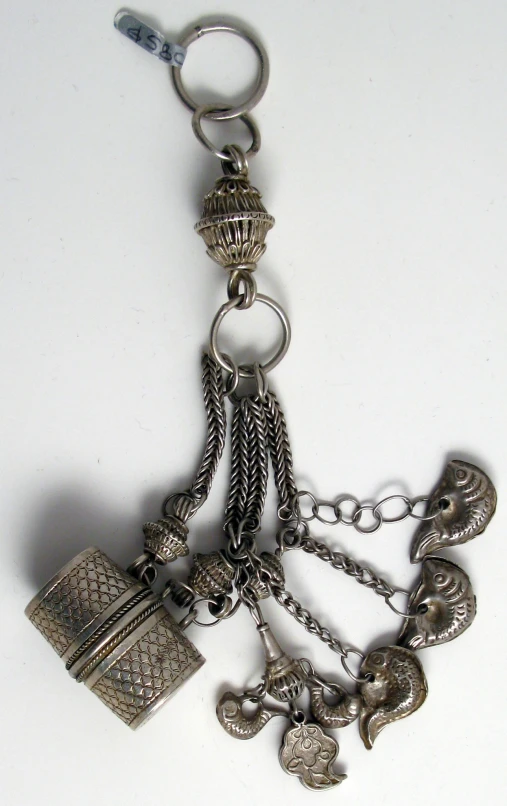 an assortment of antique silver jewelry is sitting on a white surface