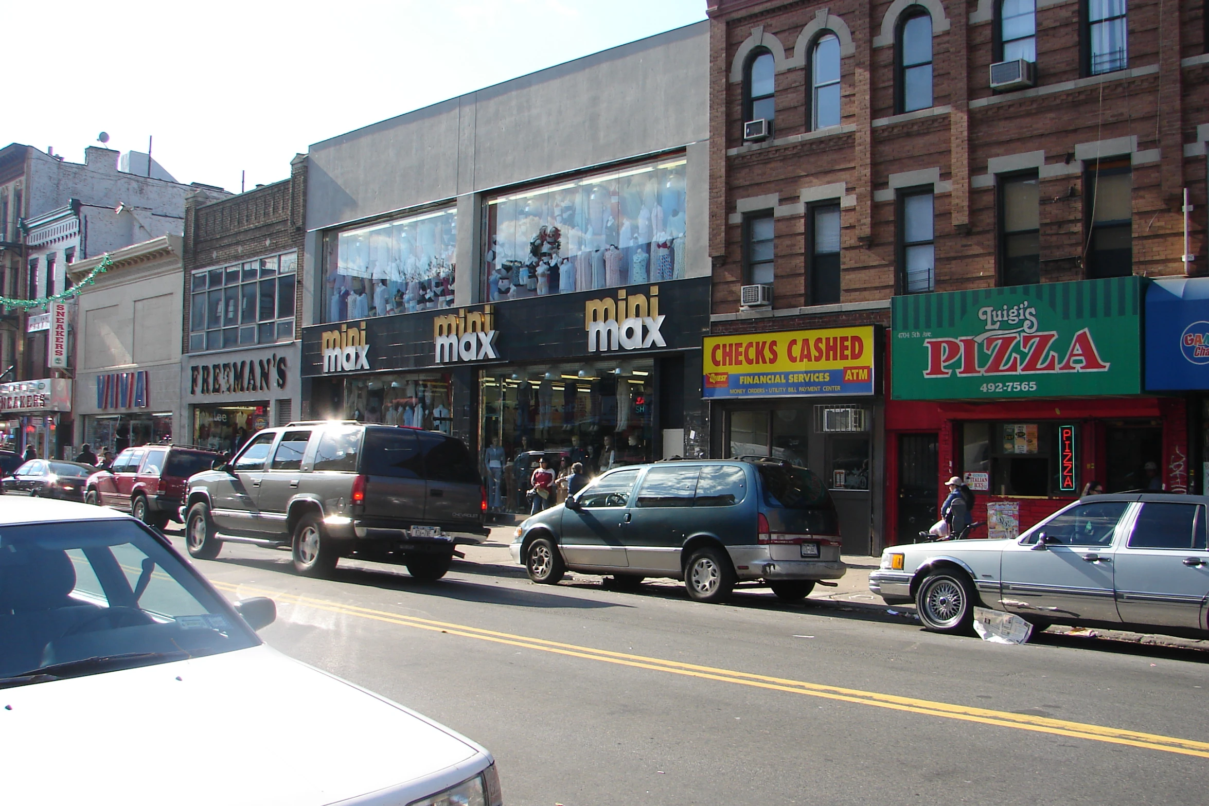 several cars parked along the curb of a busy street