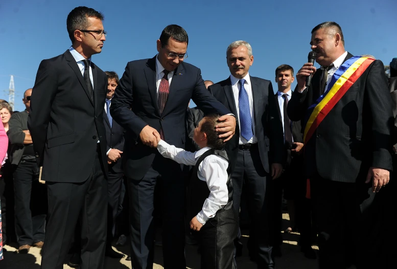 a man in suit holding hands with a child