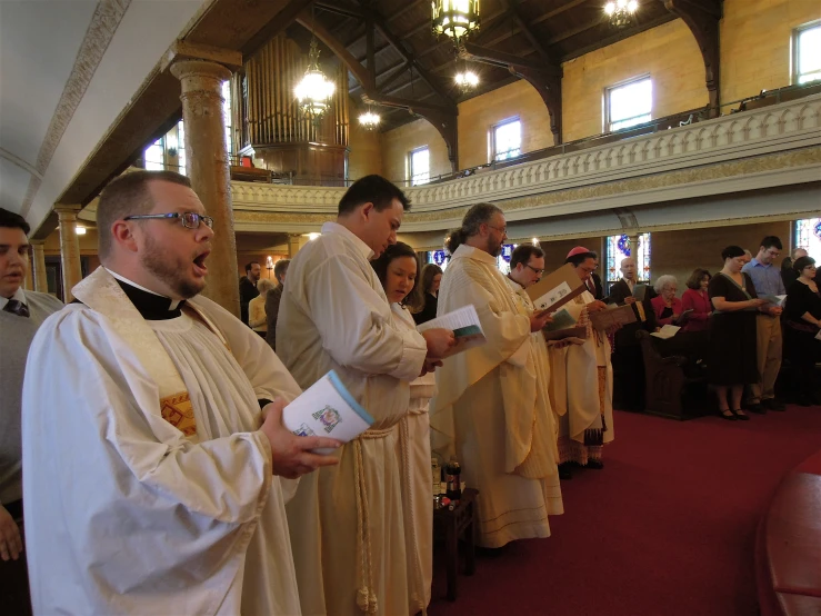 priests and clergys stand in rows in a church