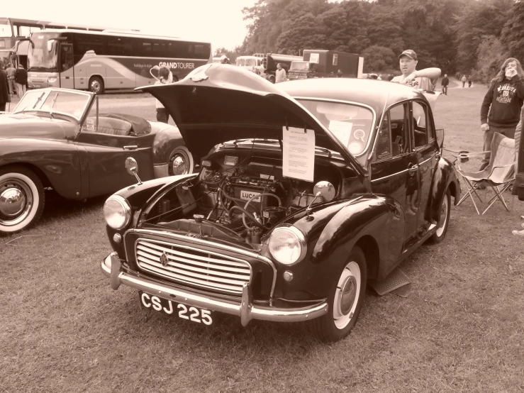 old style car with bonnet up at a car show