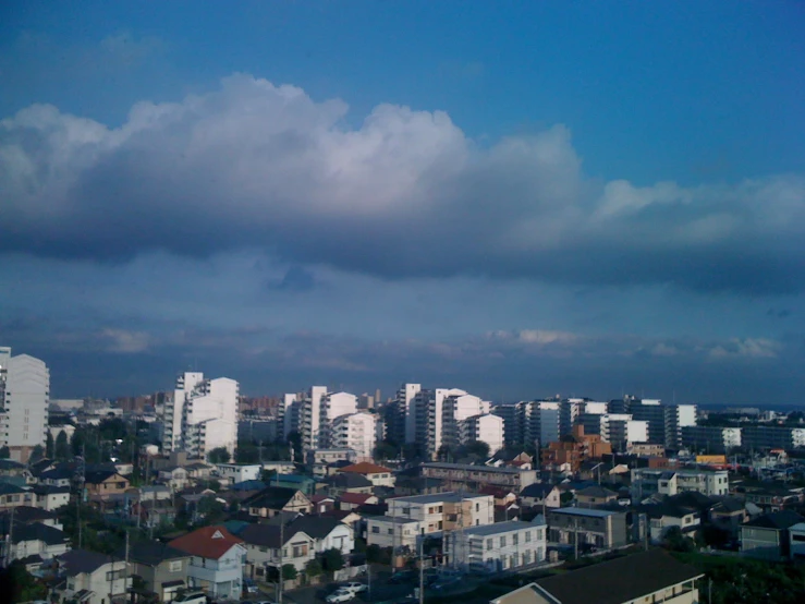 a city under cloudy skies with buildings in the foreground
