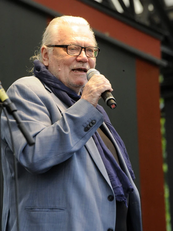 a man speaking into a microphone on stage