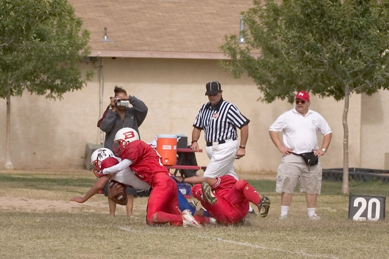 a group of football players in red jerseys playing with each other