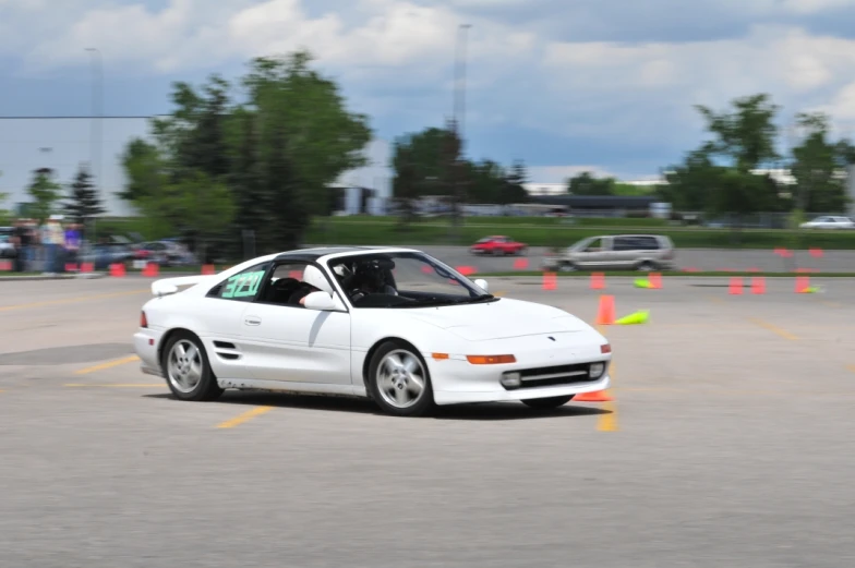 white sports car turning around the corner on the track