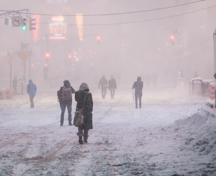 people walking in the snow on a snowy street