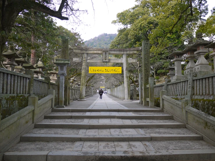 a walkway with stone steps leads up to a yellow sign that says,