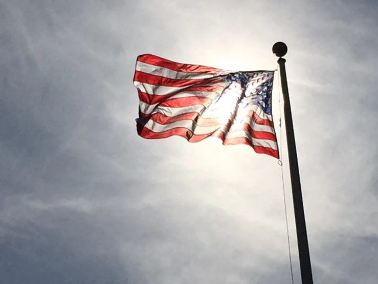 an american flag is waving on a pole