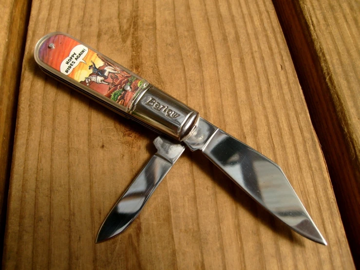 a knife is on a wooden surface next to a lighter