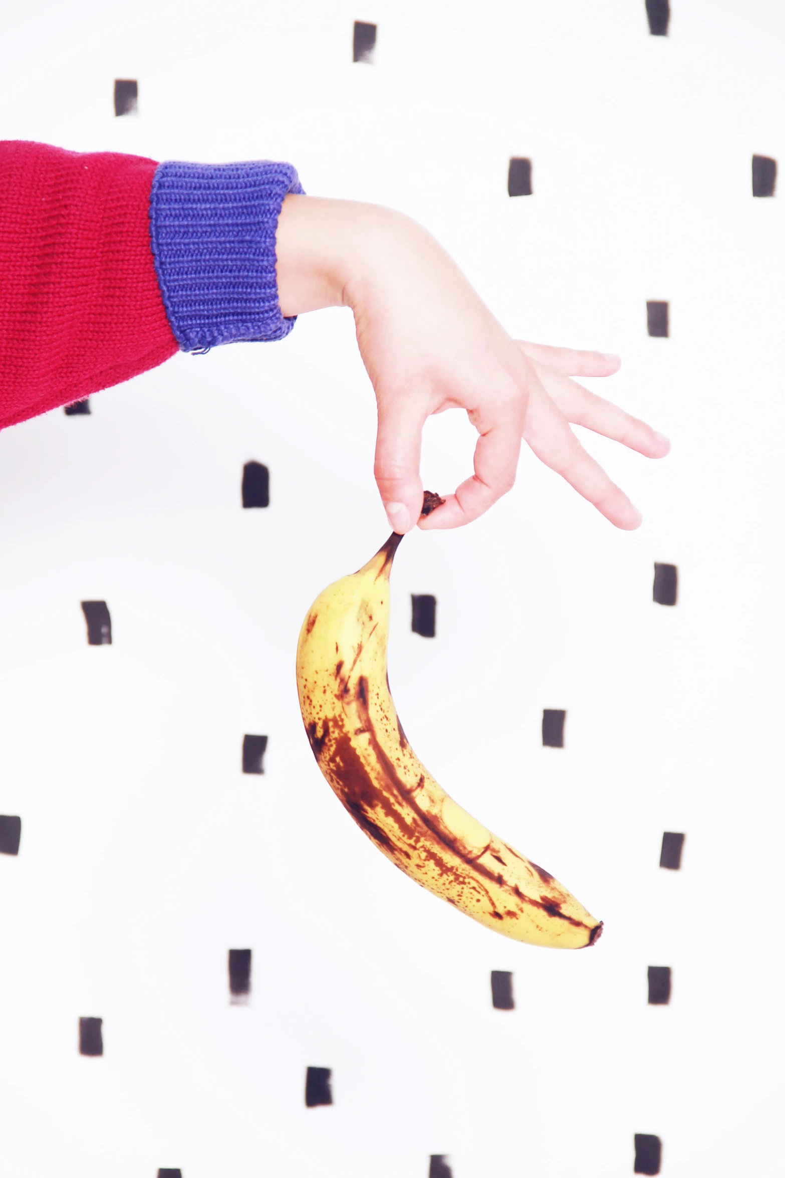 a person holding a banana and pointing it towards the ground