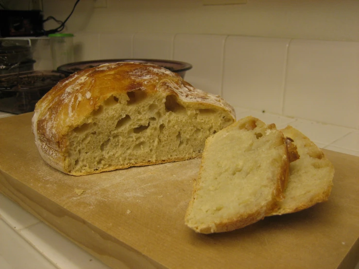 bread cut into pieces sitting on top of a  board