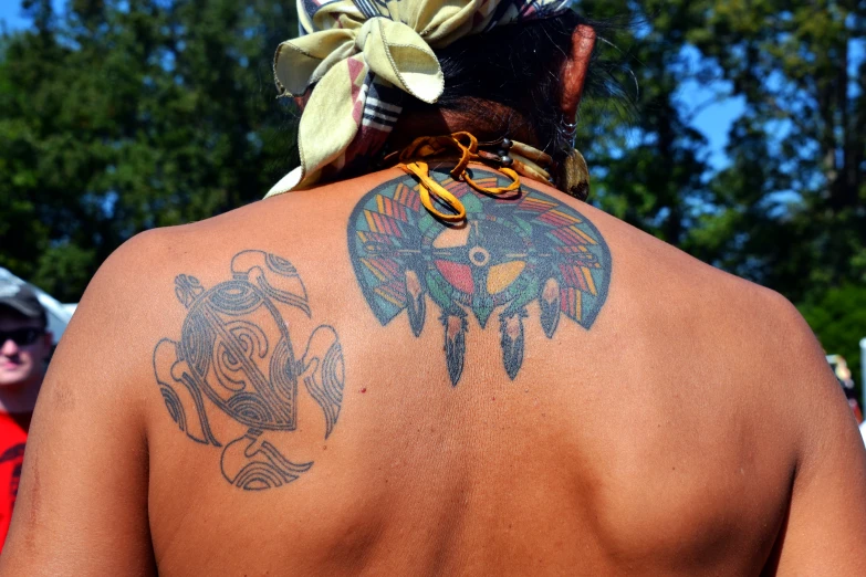 a man with tattoos standing behind his back