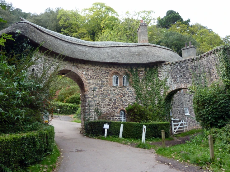 a building with a thatched roof and stone walkway leading to it